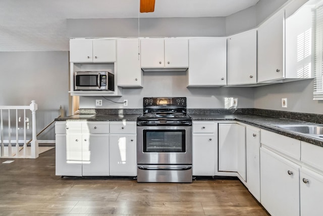 kitchen with white cabinetry, appliances with stainless steel finishes, and dark hardwood / wood-style flooring