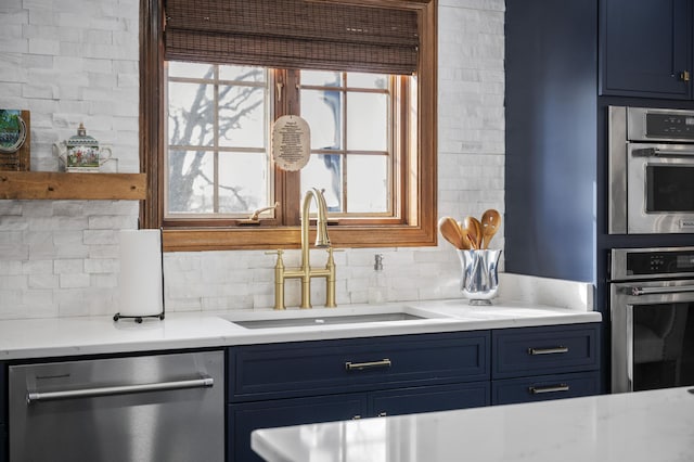 kitchen featuring sink, blue cabinetry, stainless steel dishwasher, and decorative backsplash