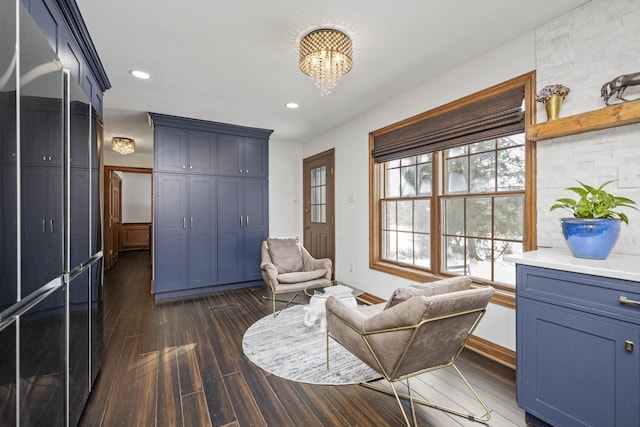 living area with dark wood-type flooring and a chandelier