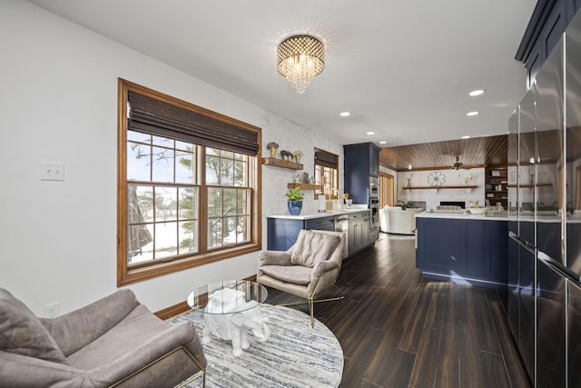 living room featuring an inviting chandelier, sink, and dark wood-type flooring