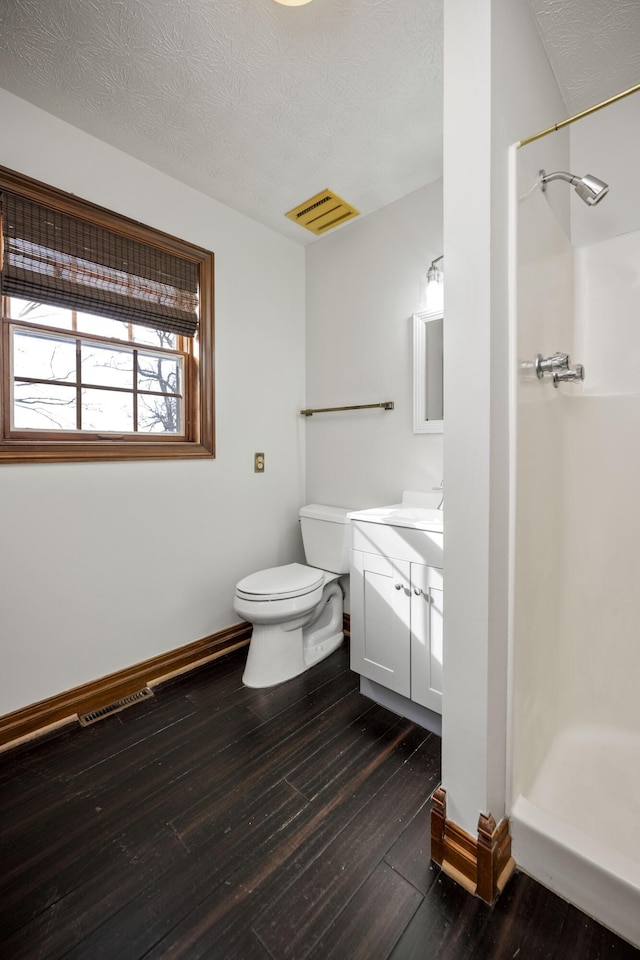 bathroom with walk in shower, toilet, wood-type flooring, a textured ceiling, and vanity