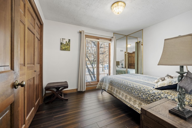 bedroom featuring a textured ceiling, dark hardwood / wood-style flooring, and a closet