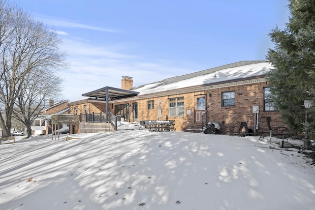 view of snow covered back of property