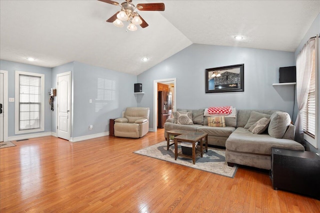 living room with vaulted ceiling, ceiling fan, and light hardwood / wood-style flooring