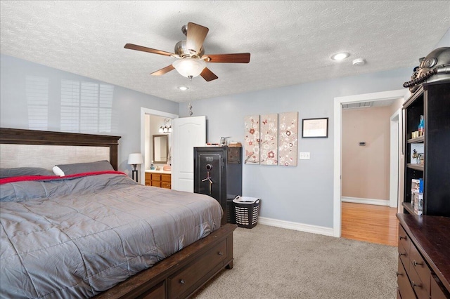 carpeted bedroom featuring a textured ceiling, ceiling fan, and ensuite bathroom