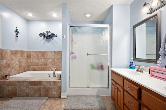 bathroom featuring tile patterned flooring, vanity, separate shower and tub, and a textured ceiling