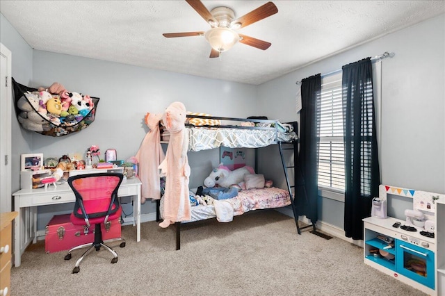 bedroom featuring ceiling fan, light colored carpet, and a textured ceiling