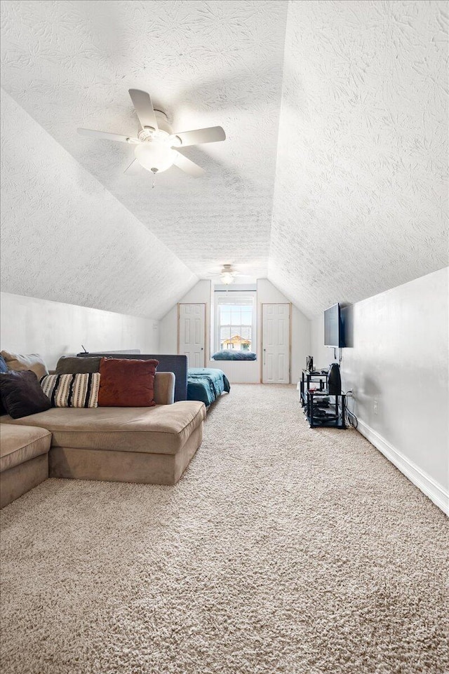 bedroom with a textured ceiling, vaulted ceiling, ceiling fan, and carpet flooring