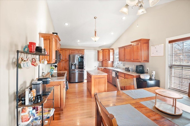 kitchen with pendant lighting, a healthy amount of sunlight, appliances with stainless steel finishes, and a kitchen island