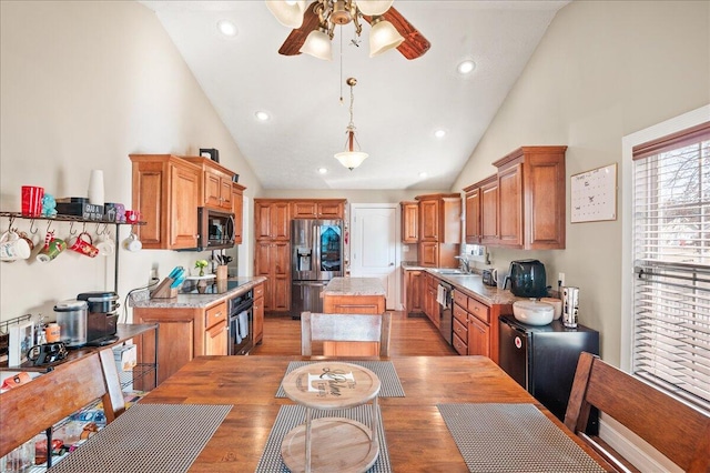 kitchen featuring pendant lighting, sink, appliances with stainless steel finishes, a center island, and light hardwood / wood-style floors