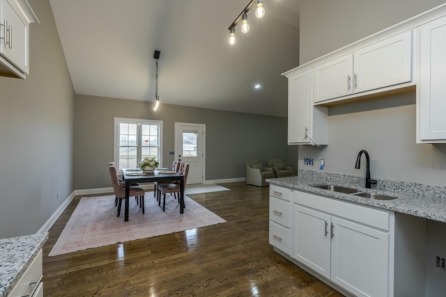 kitchen featuring sink, light stone counters, and white cabinets