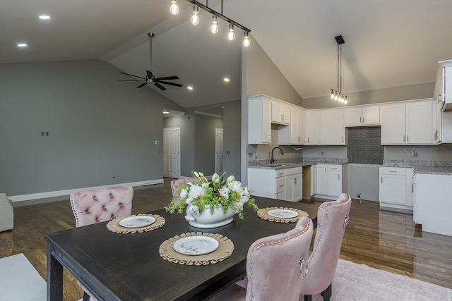 dining space with ceiling fan, high vaulted ceiling, sink, and hardwood / wood-style floors