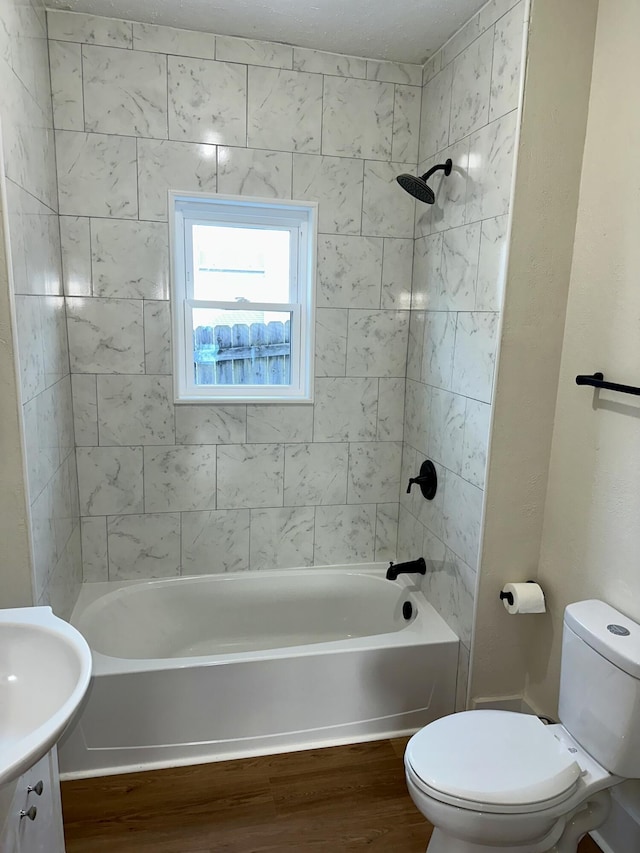 full bathroom featuring vanity, tiled shower / bath, hardwood / wood-style flooring, and toilet