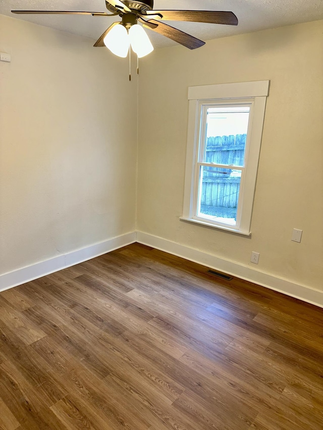 unfurnished room with dark wood-type flooring and ceiling fan