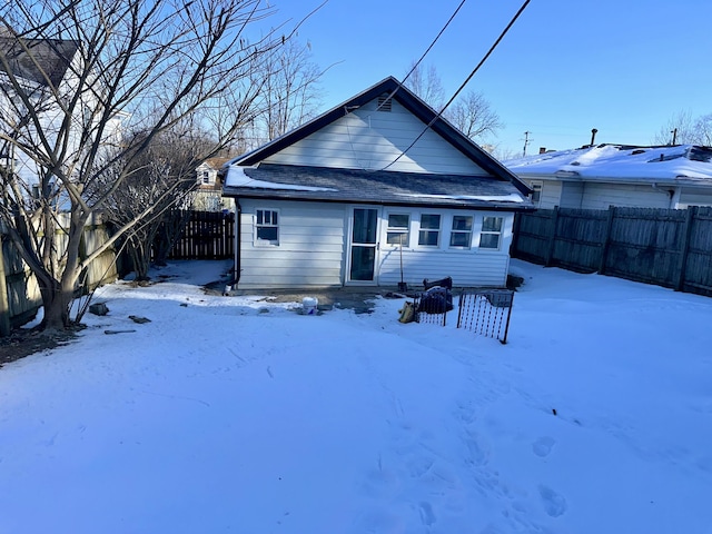 view of snow covered back of property