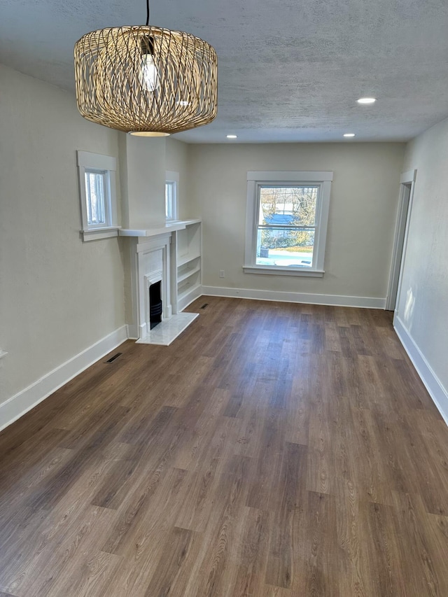 unfurnished living room with hardwood / wood-style floors and a textured ceiling