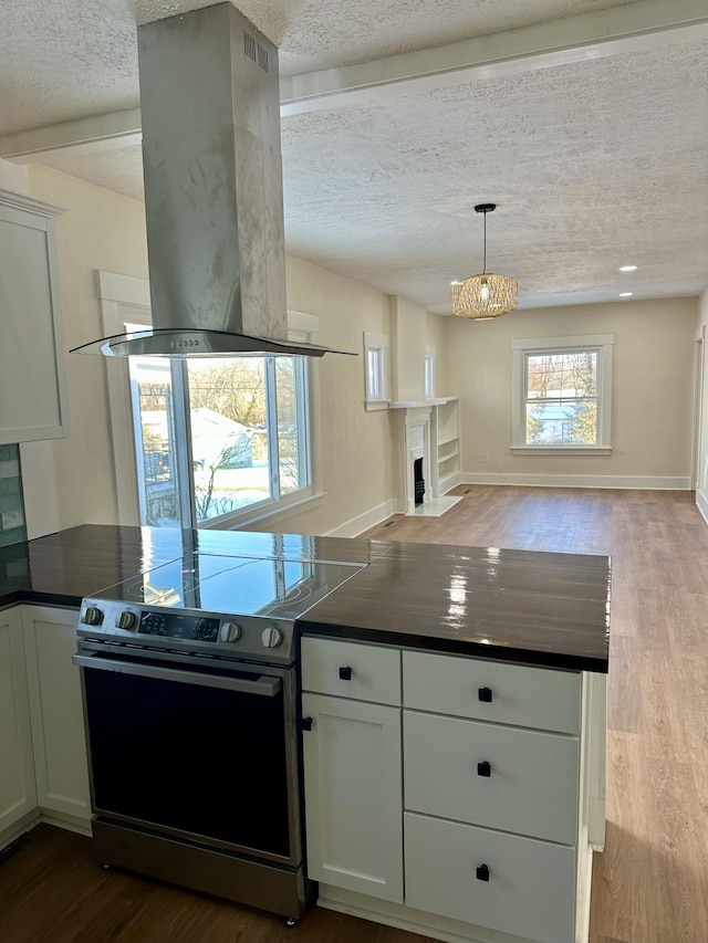 kitchen with white cabinetry, island range hood, a textured ceiling, stainless steel electric range oven, and light wood-type flooring