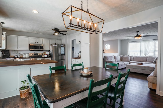 dining space featuring ceiling fan, dark hardwood / wood-style floors, and a textured ceiling