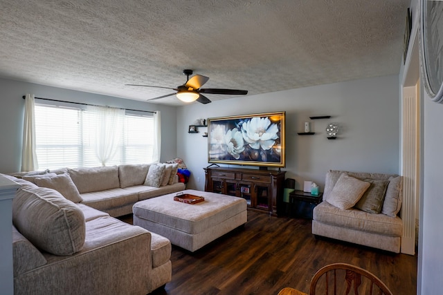 living room featuring ceiling fan, dark hardwood / wood-style floors, and a textured ceiling