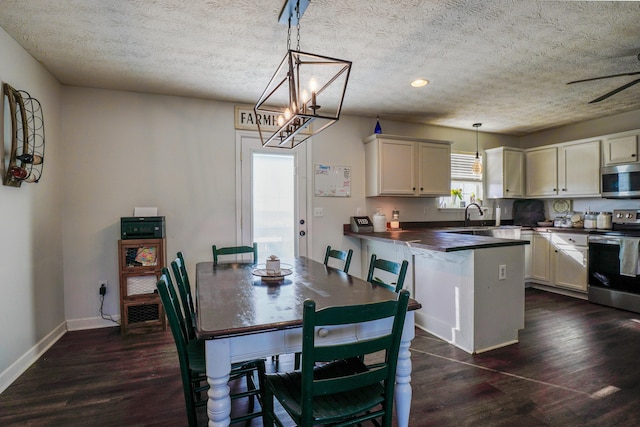 dining room featuring dark hardwood / wood-style floors, sink, and a textured ceiling