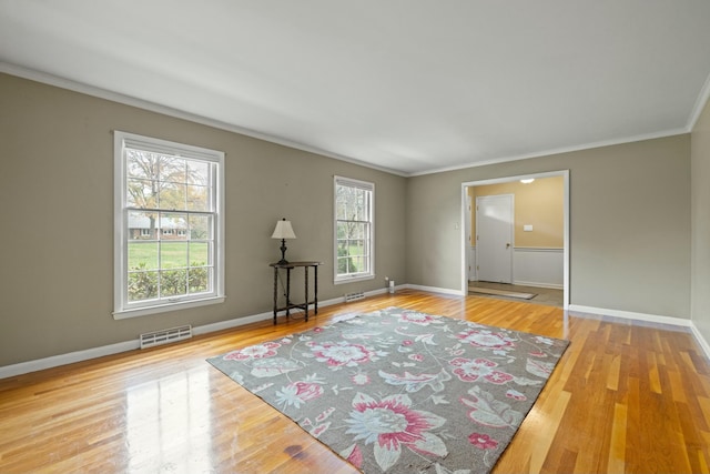 spare room featuring ornamental molding and light hardwood / wood-style floors