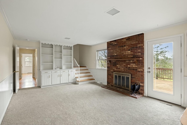 unfurnished living room featuring light colored carpet, ornamental molding, and a brick fireplace