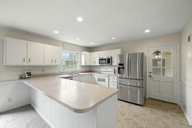 kitchen featuring white cabinetry, stainless steel appliances, kitchen peninsula, and sink