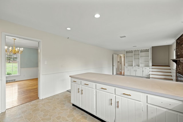 kitchen featuring white cabinetry, hanging light fixtures, and a chandelier