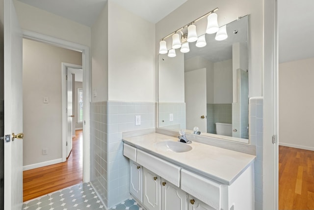 bathroom featuring vanity, toilet, and tile walls