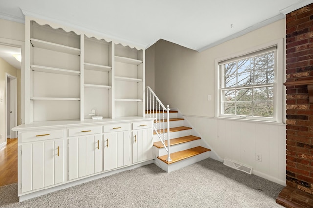 stairway featuring crown molding and carpet flooring