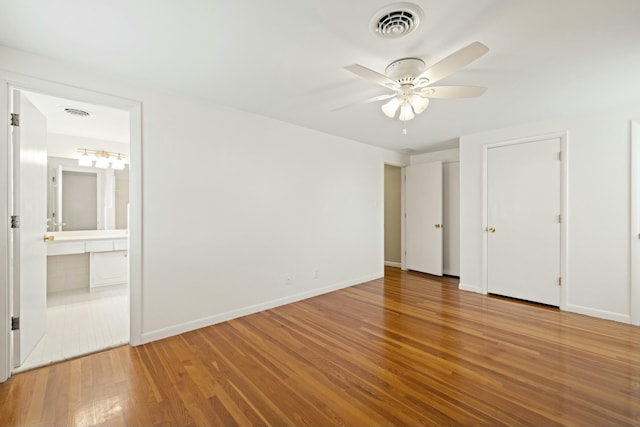 unfurnished bedroom featuring wood-type flooring, ceiling fan, and ensuite bathroom