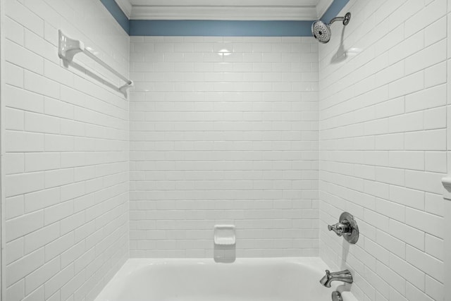 bathroom with crown molding and tiled shower / bath combo