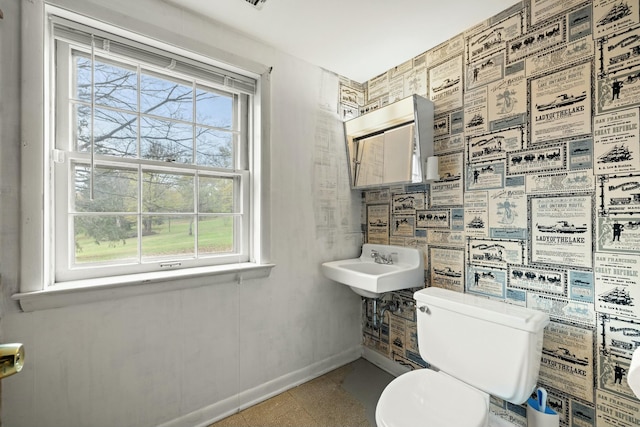 bathroom featuring a wealth of natural light and toilet