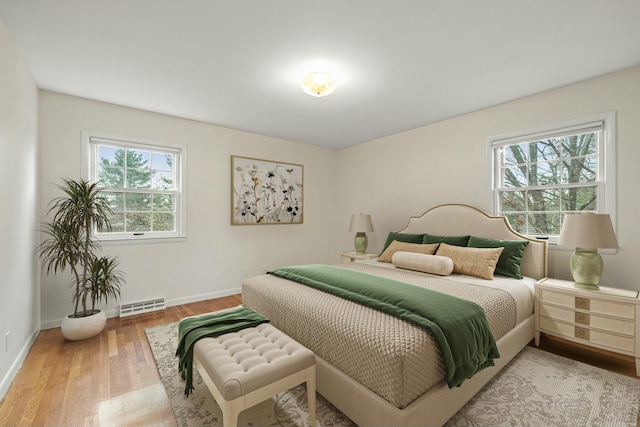 bedroom with hardwood / wood-style flooring and baseboard heating