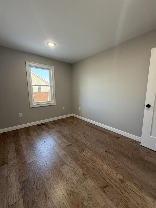 unfurnished room with dark hardwood / wood-style flooring