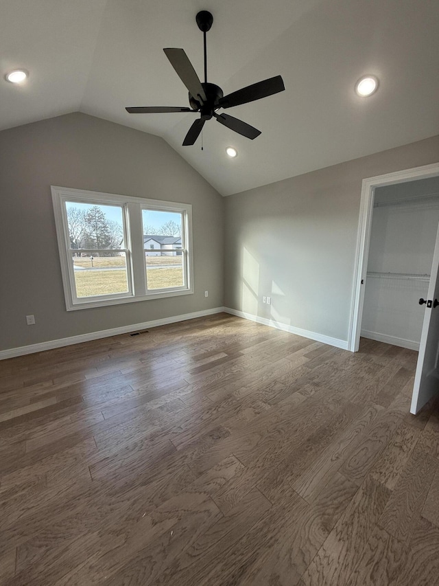 unfurnished bedroom with lofted ceiling, a closet, dark hardwood / wood-style floors, and ceiling fan