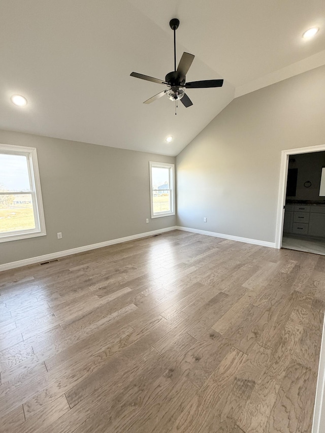 empty room featuring vaulted ceiling, ceiling fan, and light wood-type flooring