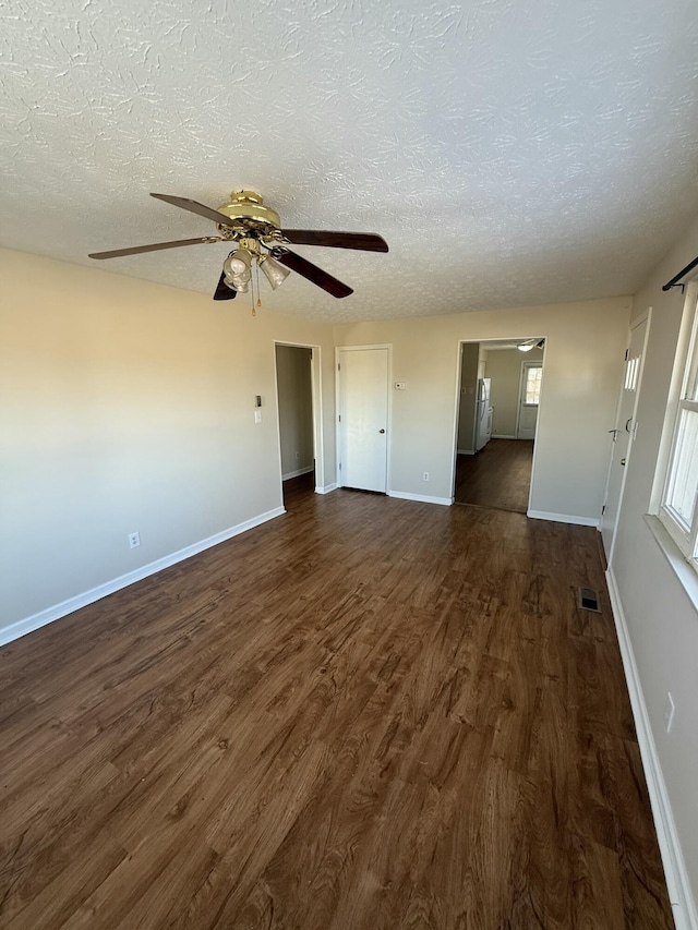 spare room featuring dark hardwood / wood-style flooring, ceiling fan, and a textured ceiling