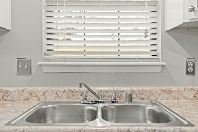 kitchen featuring sink and white cabinets