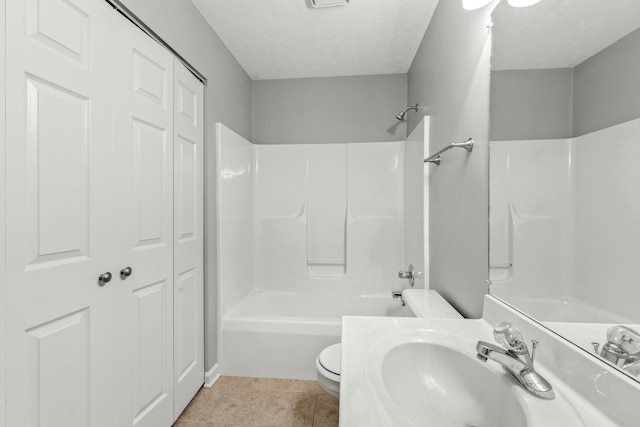 full bathroom with sink, tile patterned flooring, shower / bath combination, toilet, and a textured ceiling