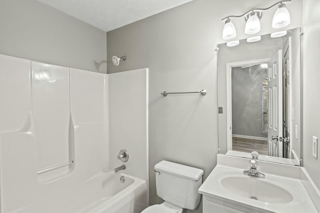 full bathroom with vanity, toilet, a textured ceiling, and  shower combination