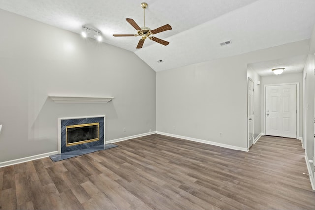 unfurnished living room featuring hardwood / wood-style flooring, ceiling fan, lofted ceiling, and a textured ceiling