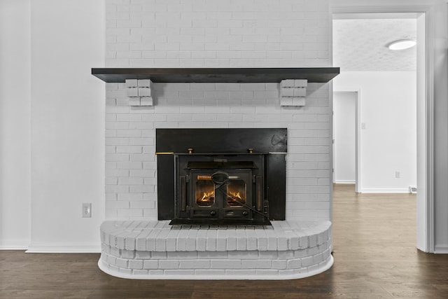 interior details with wood-type flooring and a fireplace