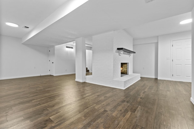 unfurnished living room featuring dark wood-type flooring and a fireplace