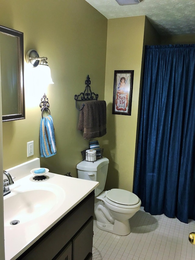 bathroom with vanity, tile patterned floors, toilet, and a textured ceiling