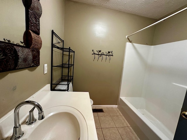 full bathroom featuring shower / bathing tub combination, sink, tile patterned flooring, toilet, and a textured ceiling