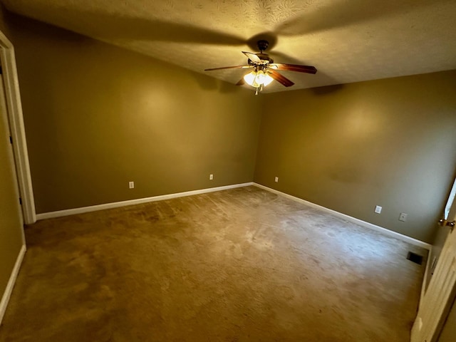 carpeted empty room with ceiling fan and a textured ceiling