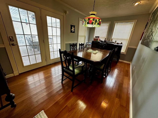 dining space featuring crown molding, plenty of natural light, wood-type flooring, and a textured ceiling