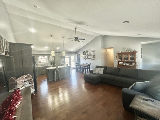 living room with dark wood-type flooring, ceiling fan, and vaulted ceiling