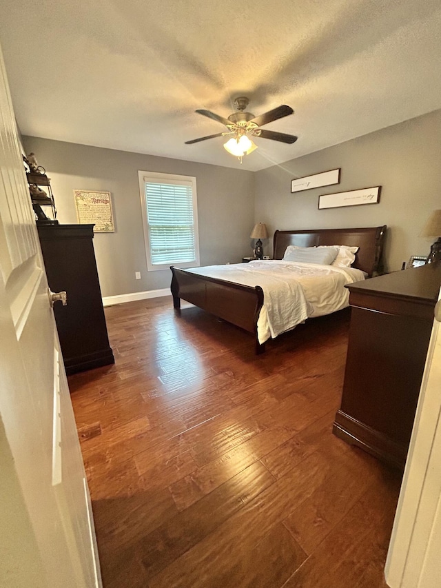 bedroom featuring dark hardwood / wood-style floors, a textured ceiling, and ceiling fan